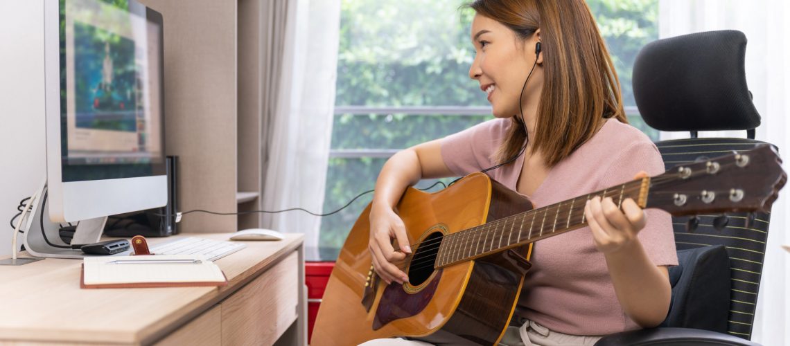 Young,Asian,Woman,Playing,Guitar,Live-stream,Vlogger,Online-lesson,On,Computer